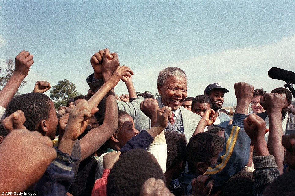 Support for change: ANC president Nelson Mandela is surrounded by young supporters after addressing residents at Phola Park, a squatter settlement east of Johannesburg, 31 May 1992